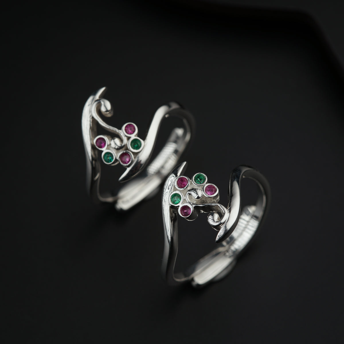 a pair of silver rings with colored stones