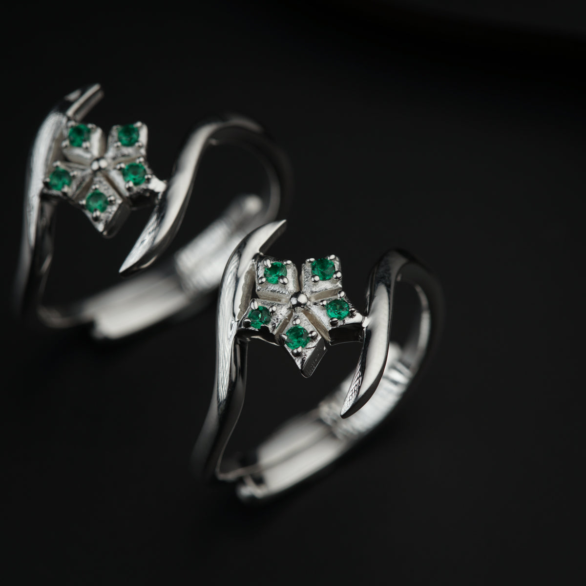 a couple of rings with green stones on them