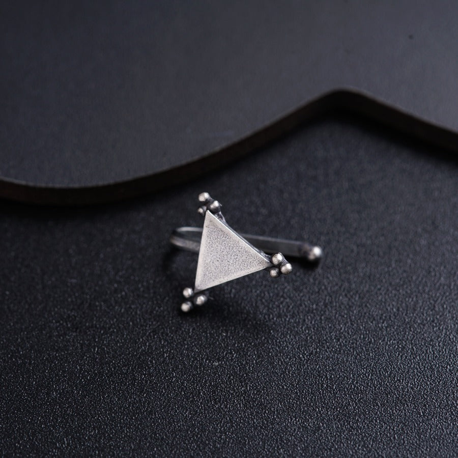 a triangle shaped ring sitting on top of a black surface