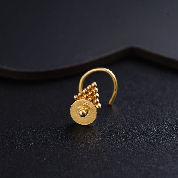 a close up of a gold ring on a black surface