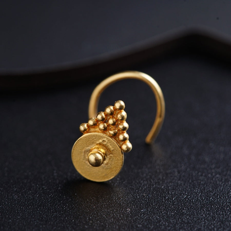 a close up of a gold ring on a black surface