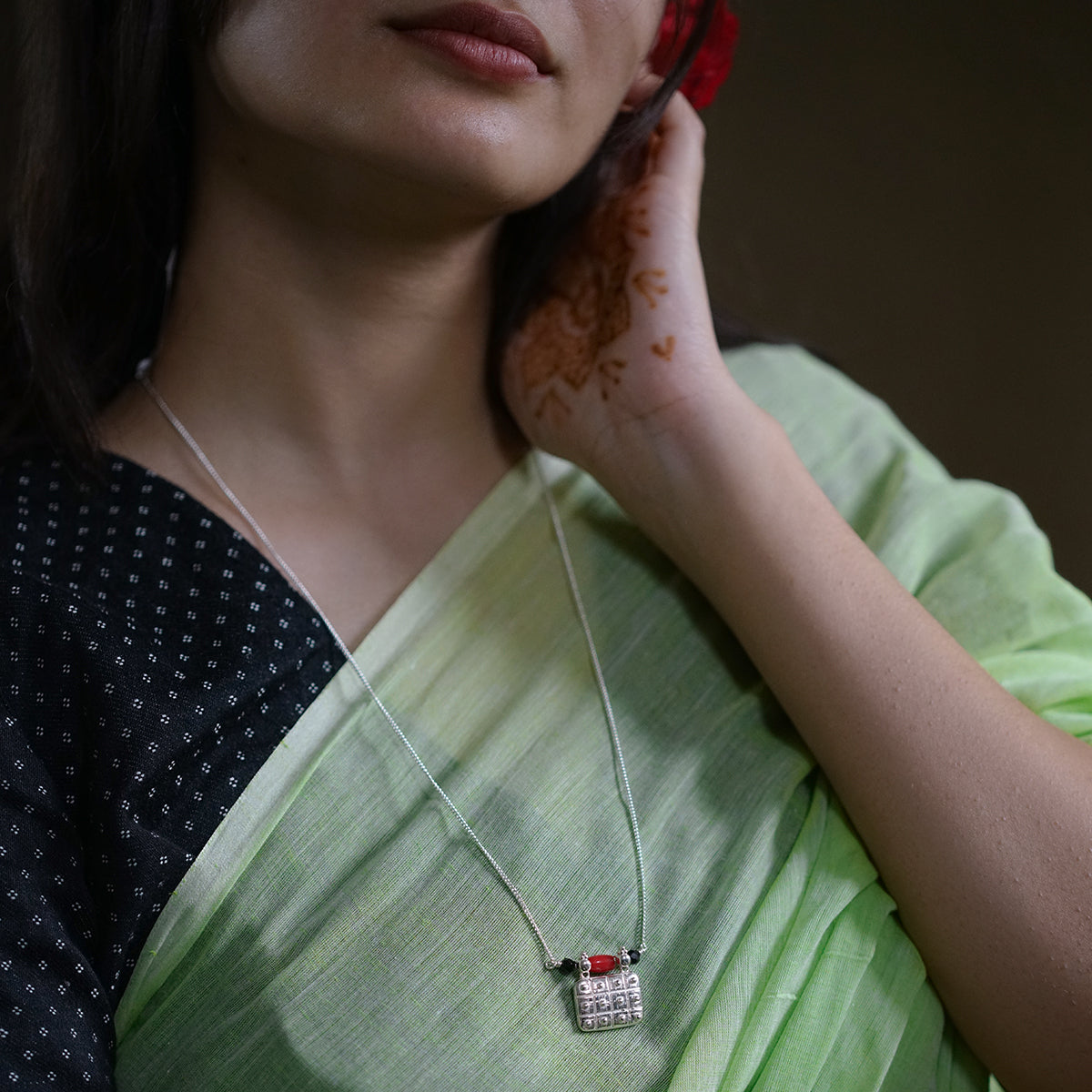 a woman in a green sari holding a cell phone to her ear