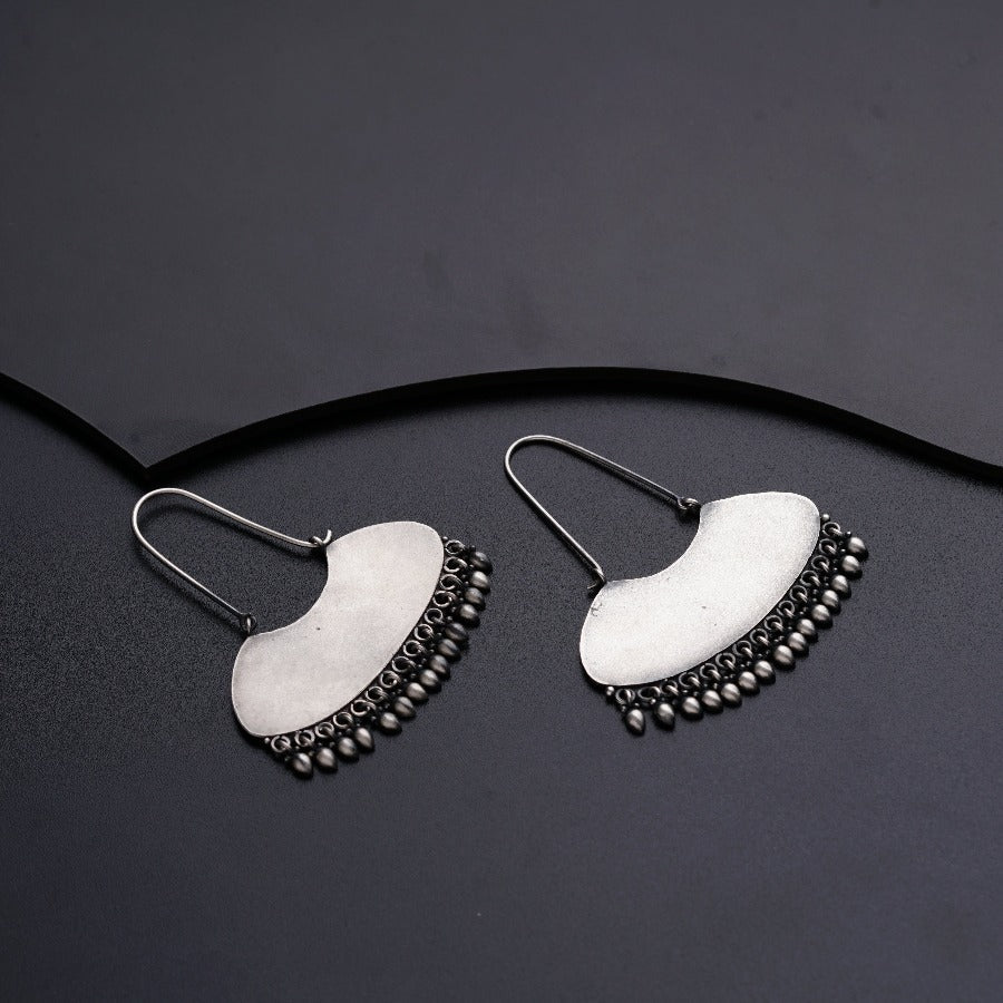 a pair of earrings on a black surface