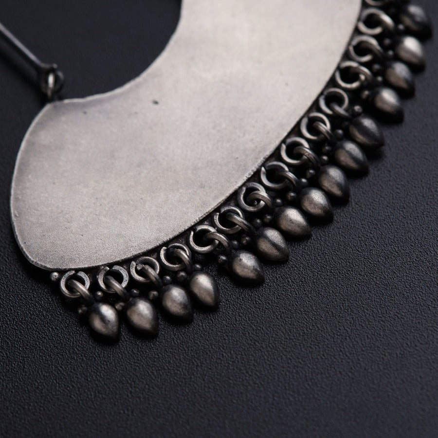 a close up of a necklace on a black surface
