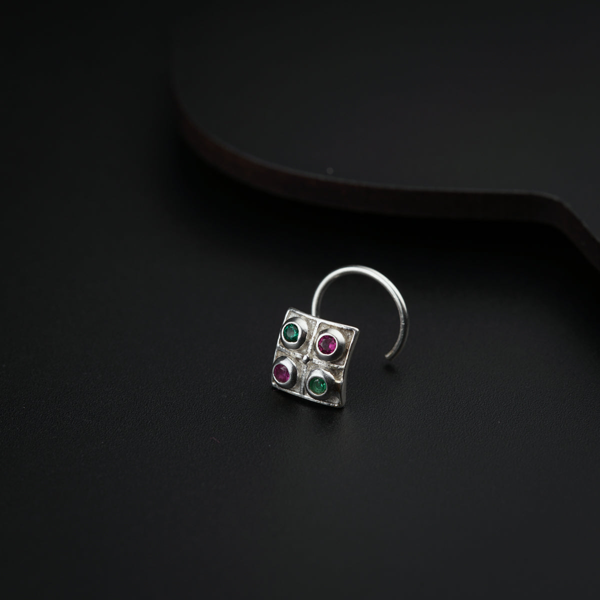 a close up of a pair of earrings on a black surface