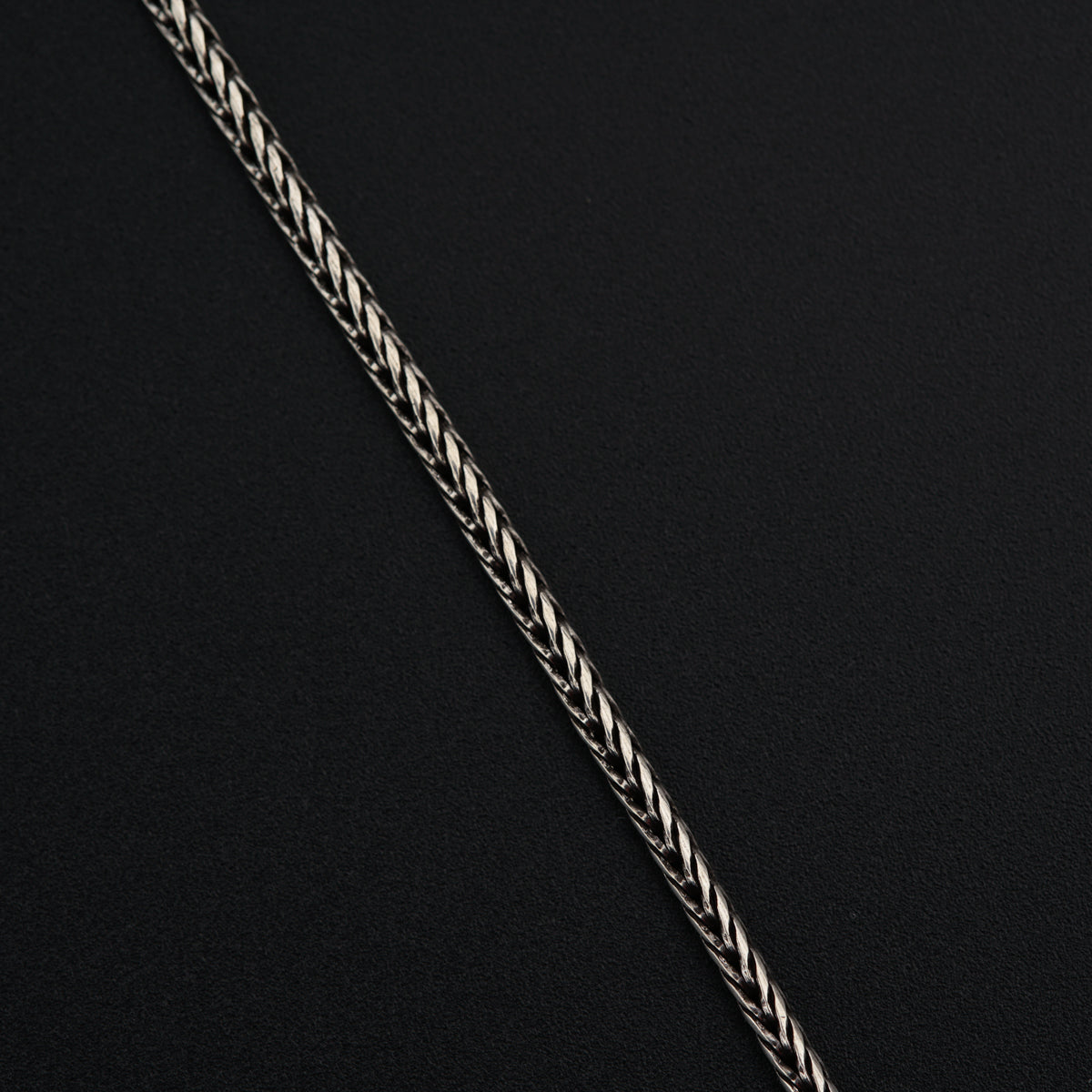 a close up of a chain on a black surface