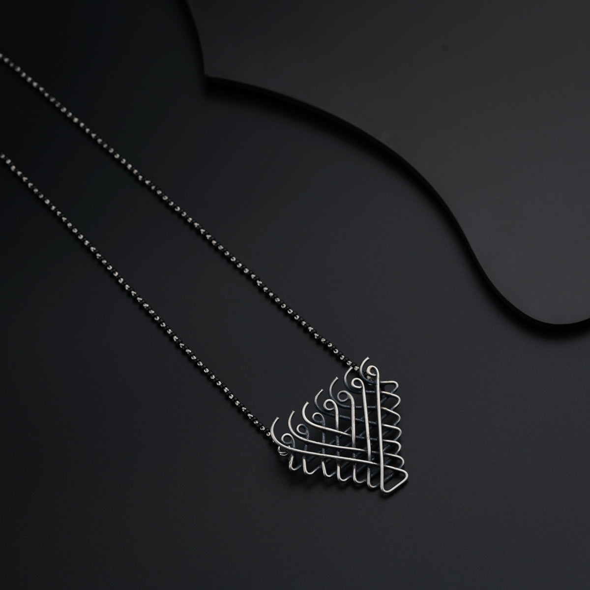a necklace with a design on it on a black surface