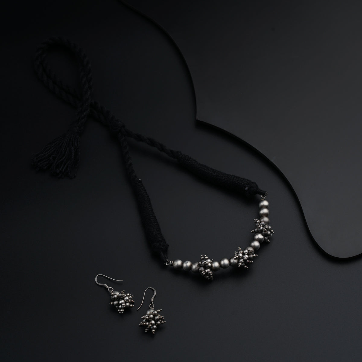 a necklace and earrings on a black surface