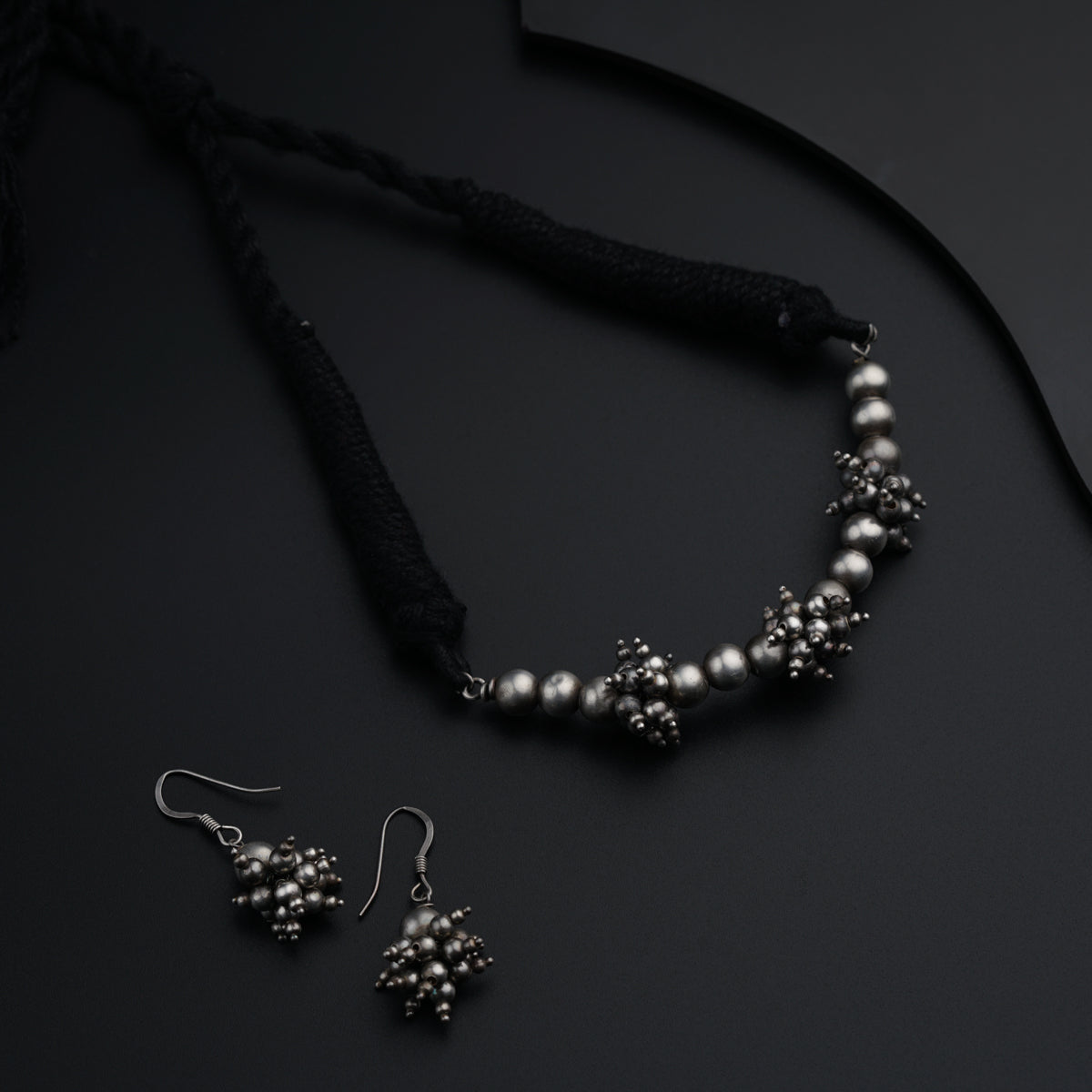 a necklace and earrings on a black surface