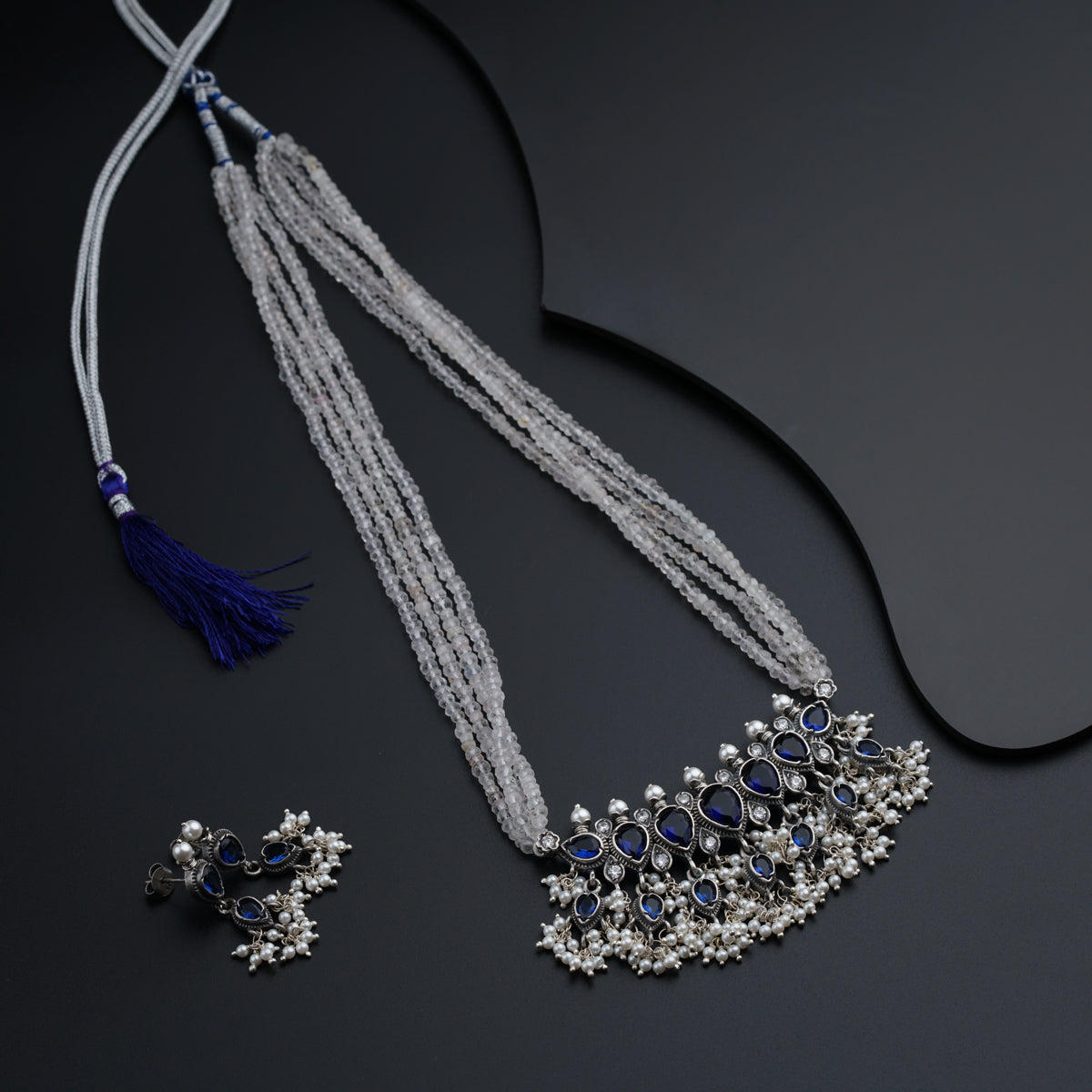 a necklace with a tassel and a pair of earrings