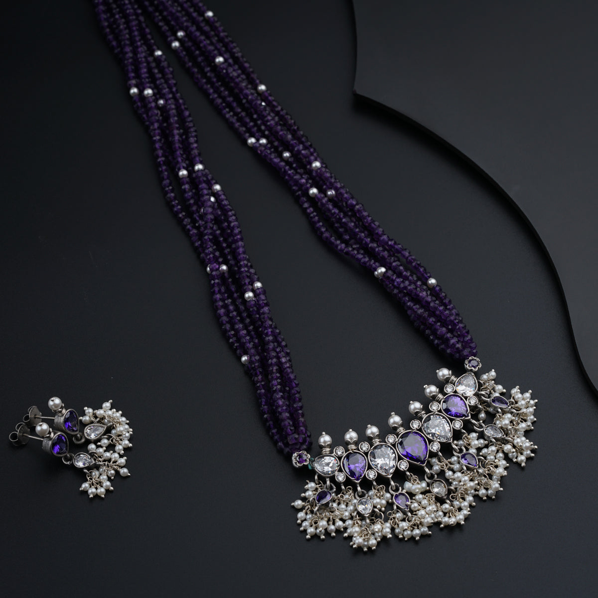 a necklace and earring with a purple bead