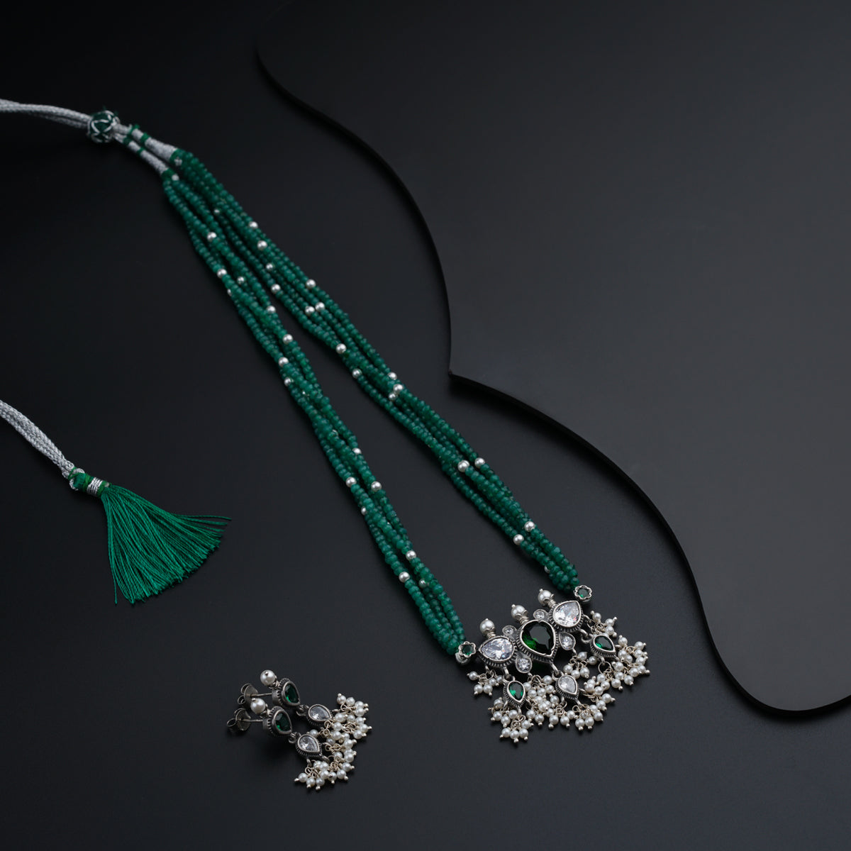 a necklace and earring with a tassel
