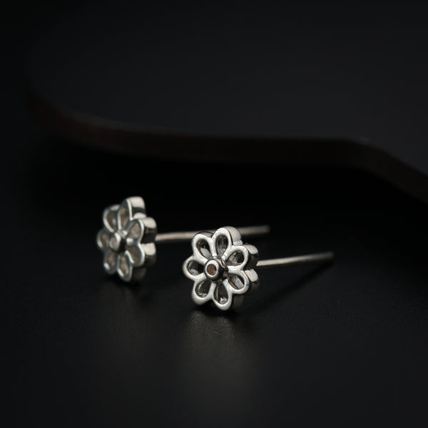 Close-up of silver flower earrings on black background