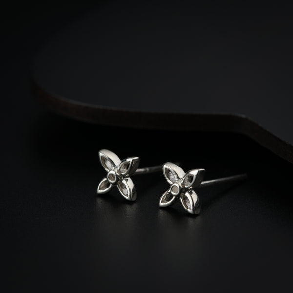 Silver flower earrings on black background