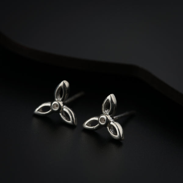 Close-up of silver flower stud earrings on black background