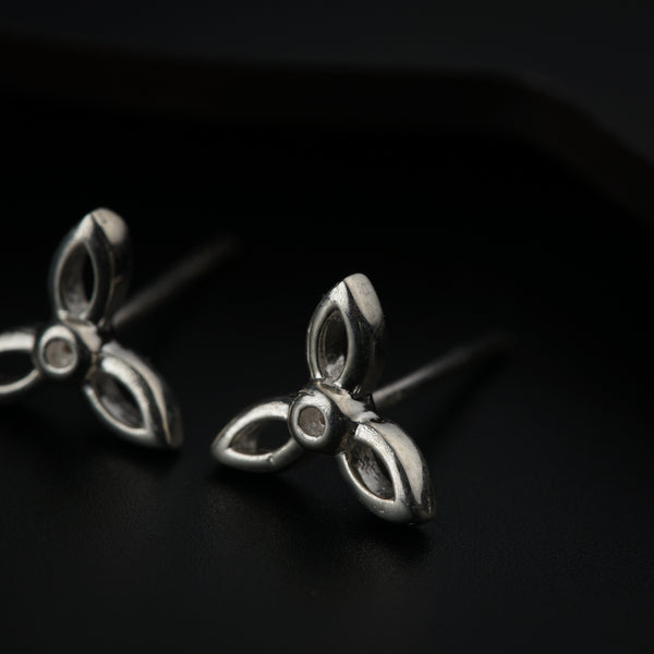 Silver flower earrings with butterfly back on black surface