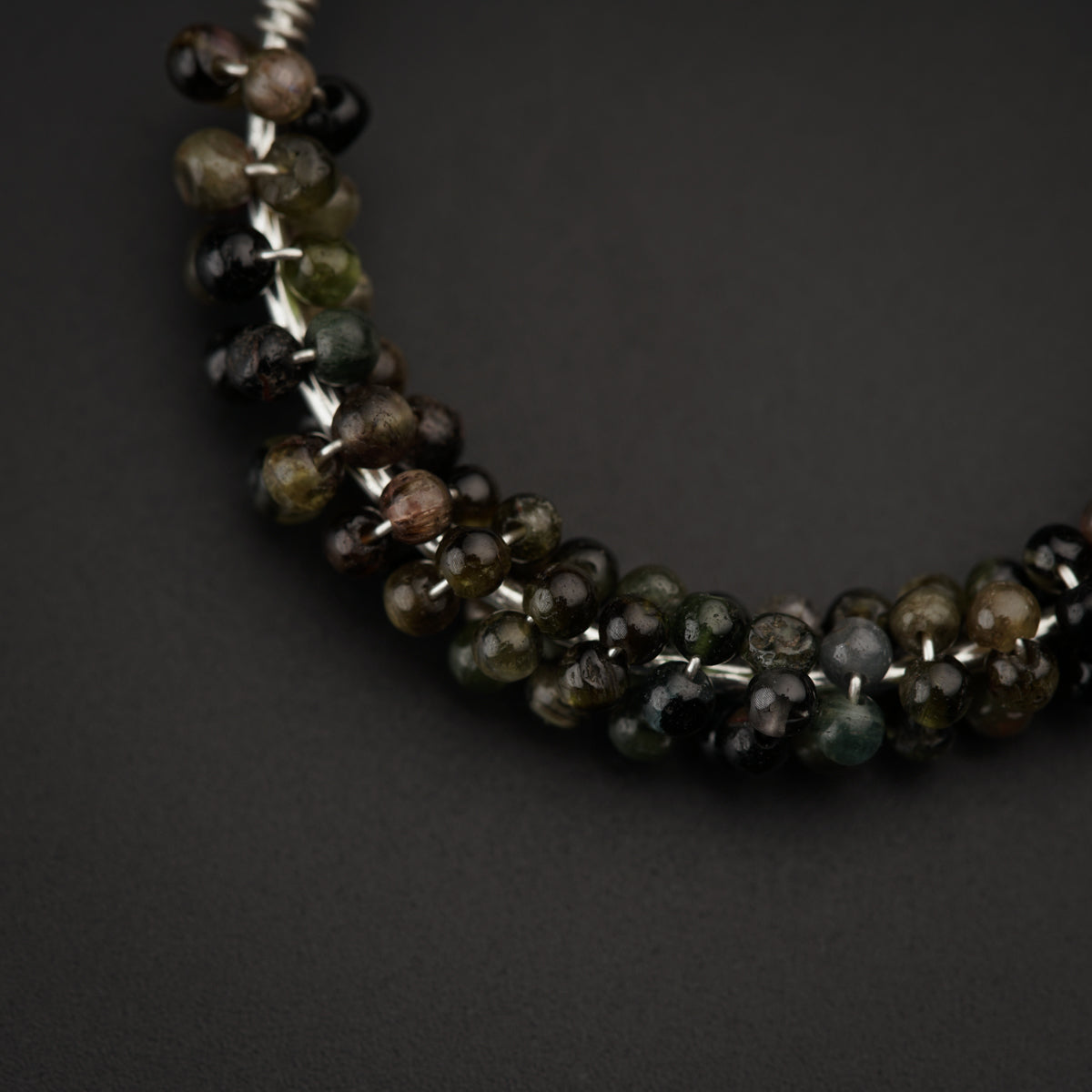 a close up of a beaded necklace on a black surface