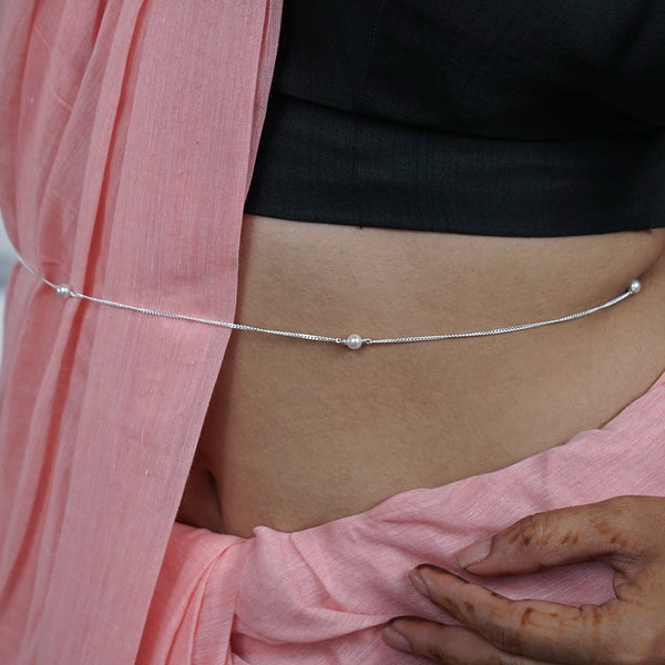 Pearl waist chain on bare skin with pink and black clothing