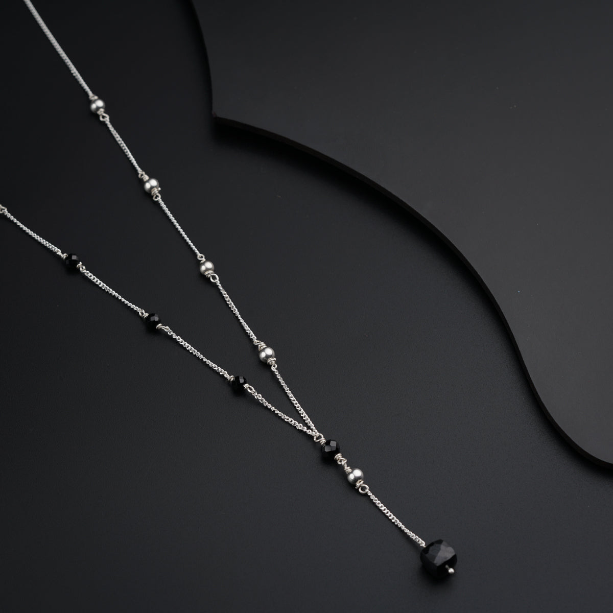 a black and silver necklace on a black background