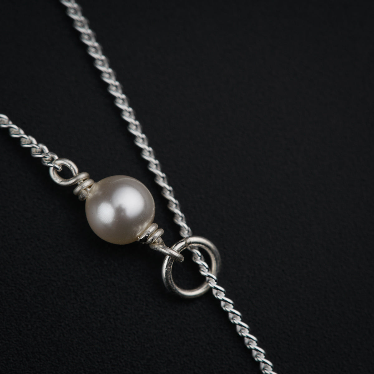 a necklace with a pearl on a chain