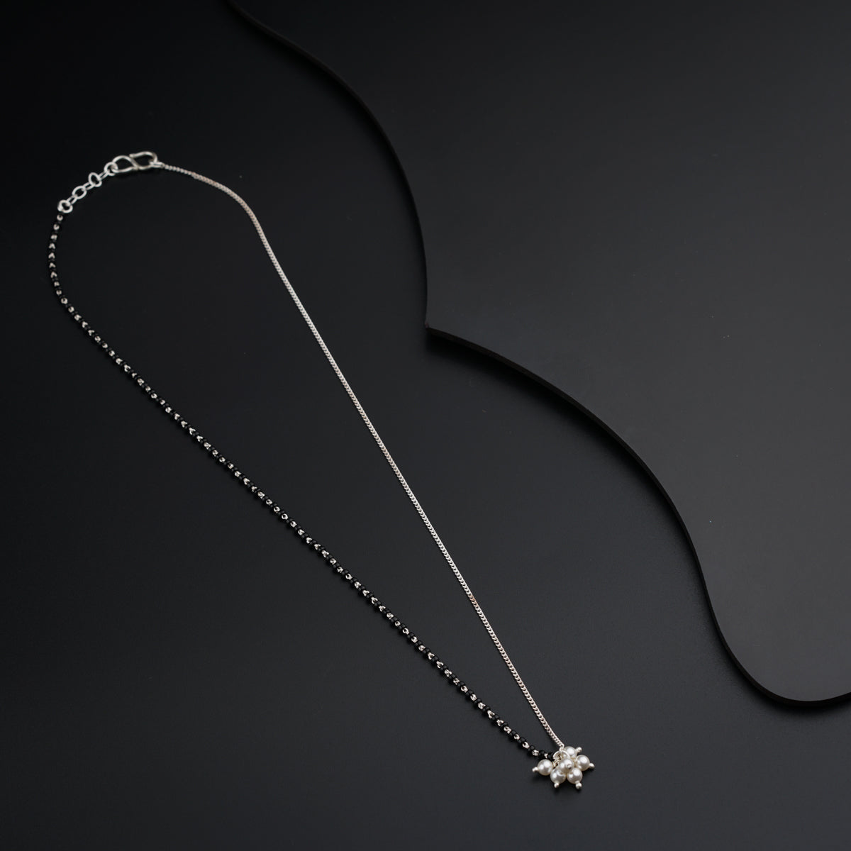 a necklace with a cross on a black background