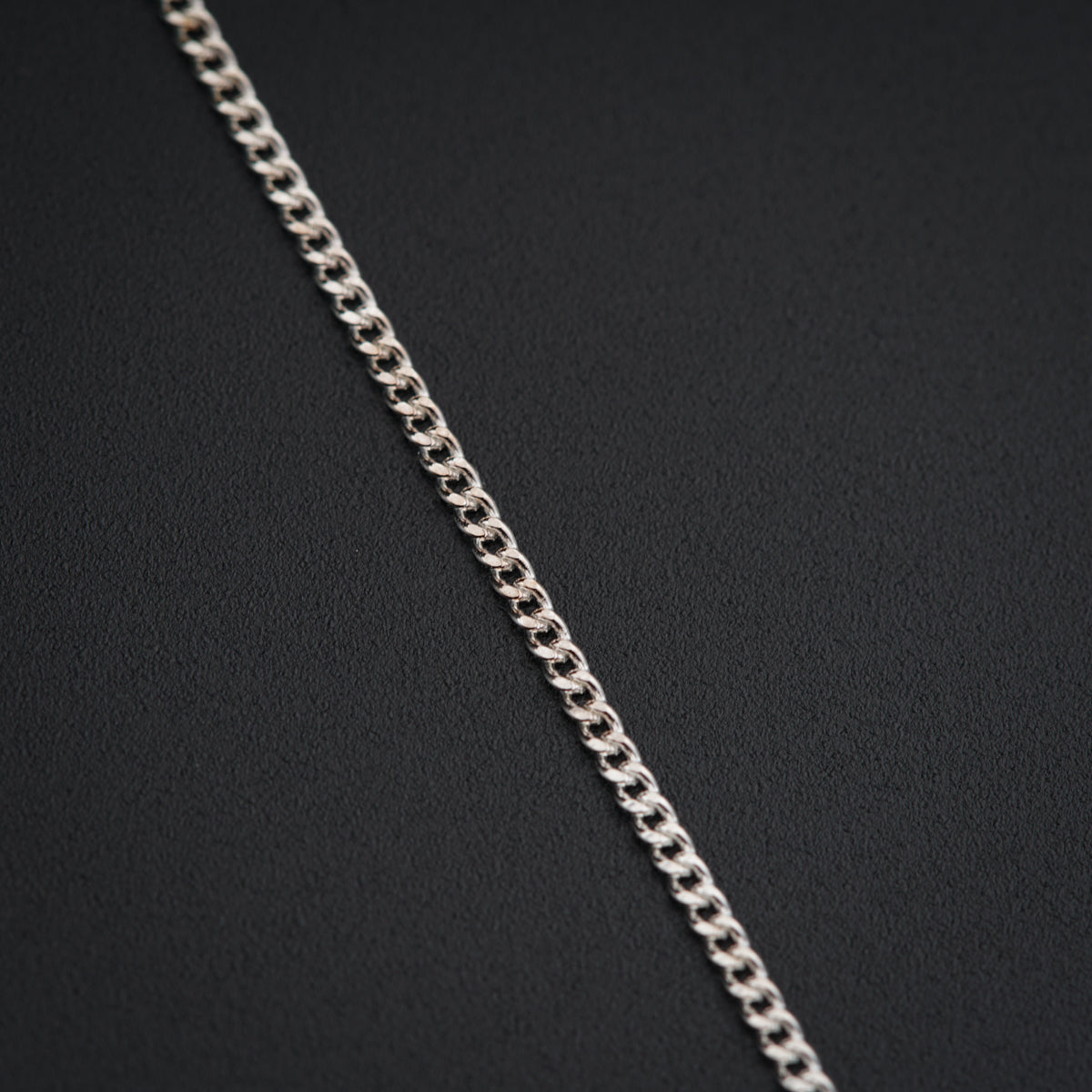 a close up of a chain on a black surface