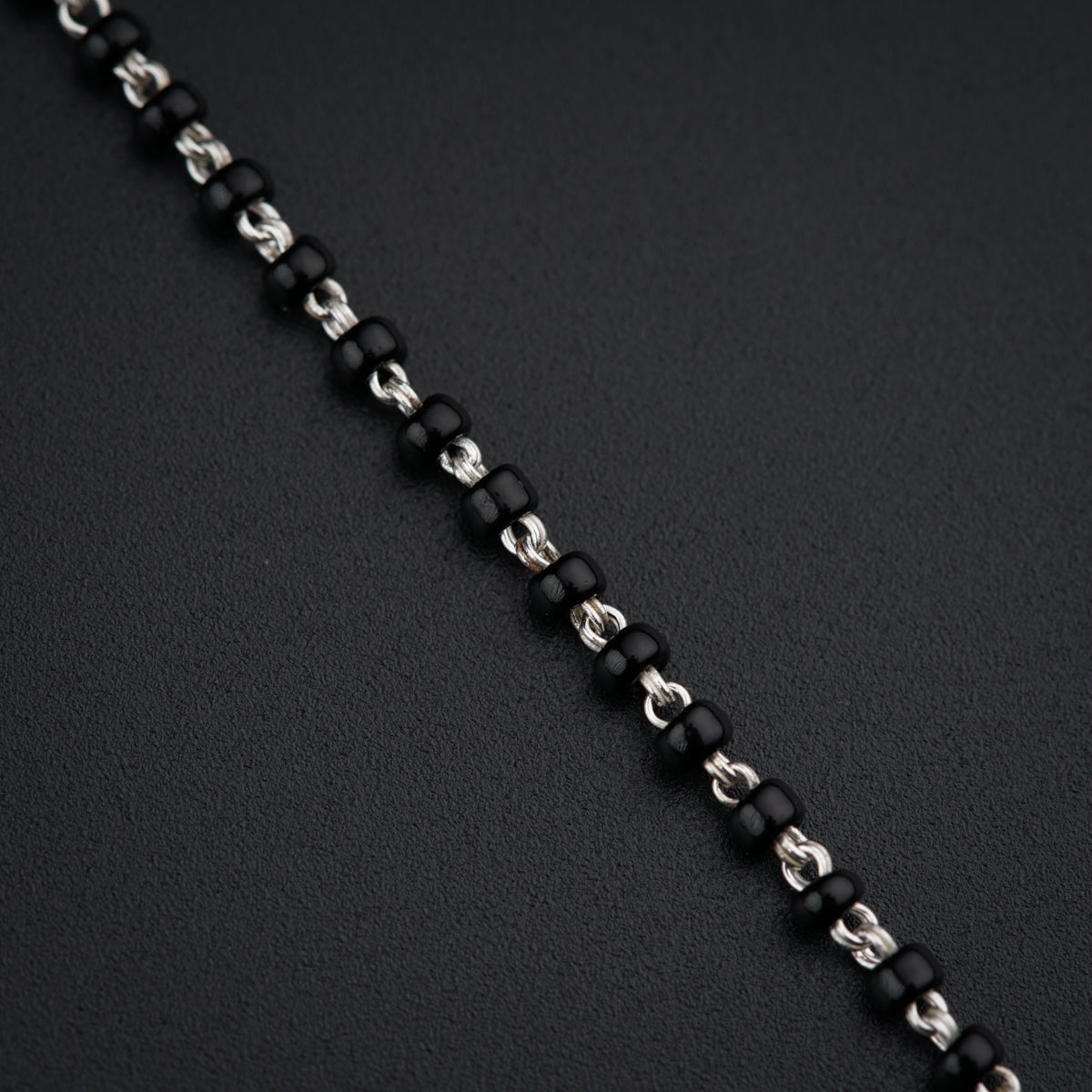a close up of a chain on a black surface