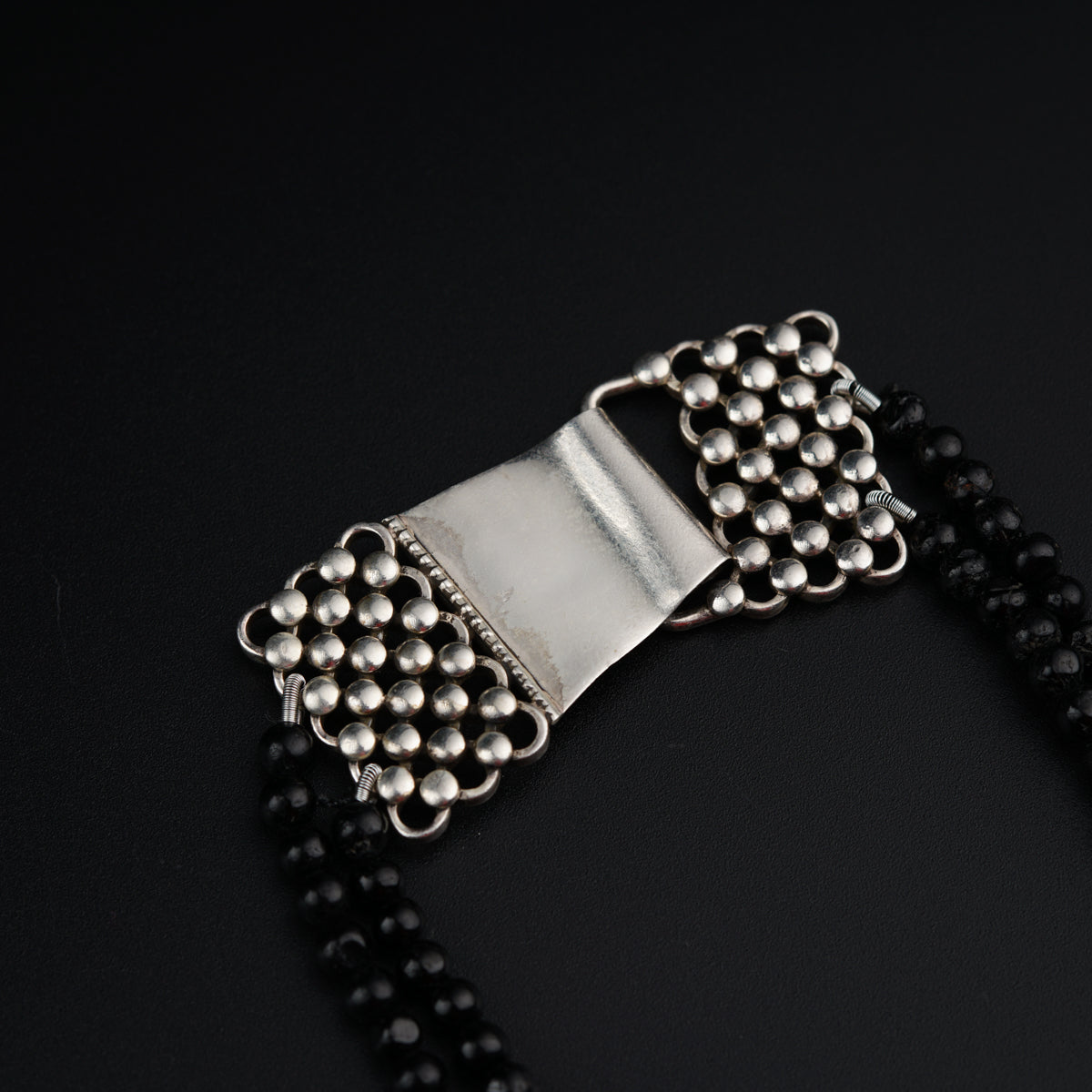 a black beaded necklace with a silver buckle