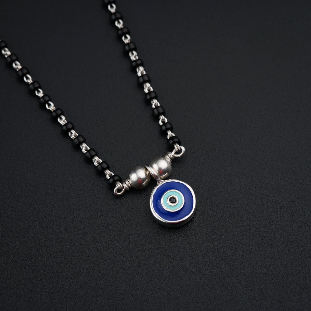 a necklace with a blue evil eye on it