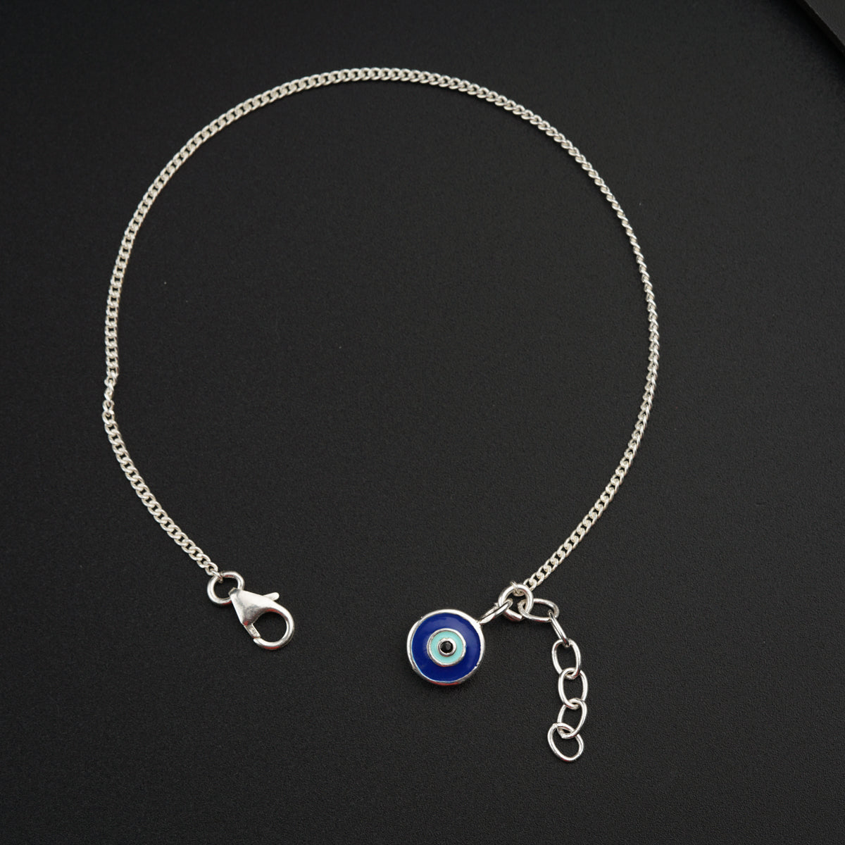 a blue evil eye charm on a silver chain