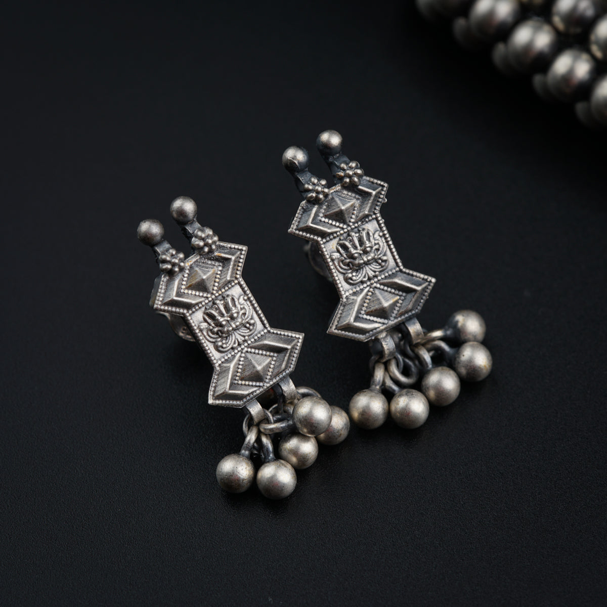 a close up of a pair of earrings on a black surface