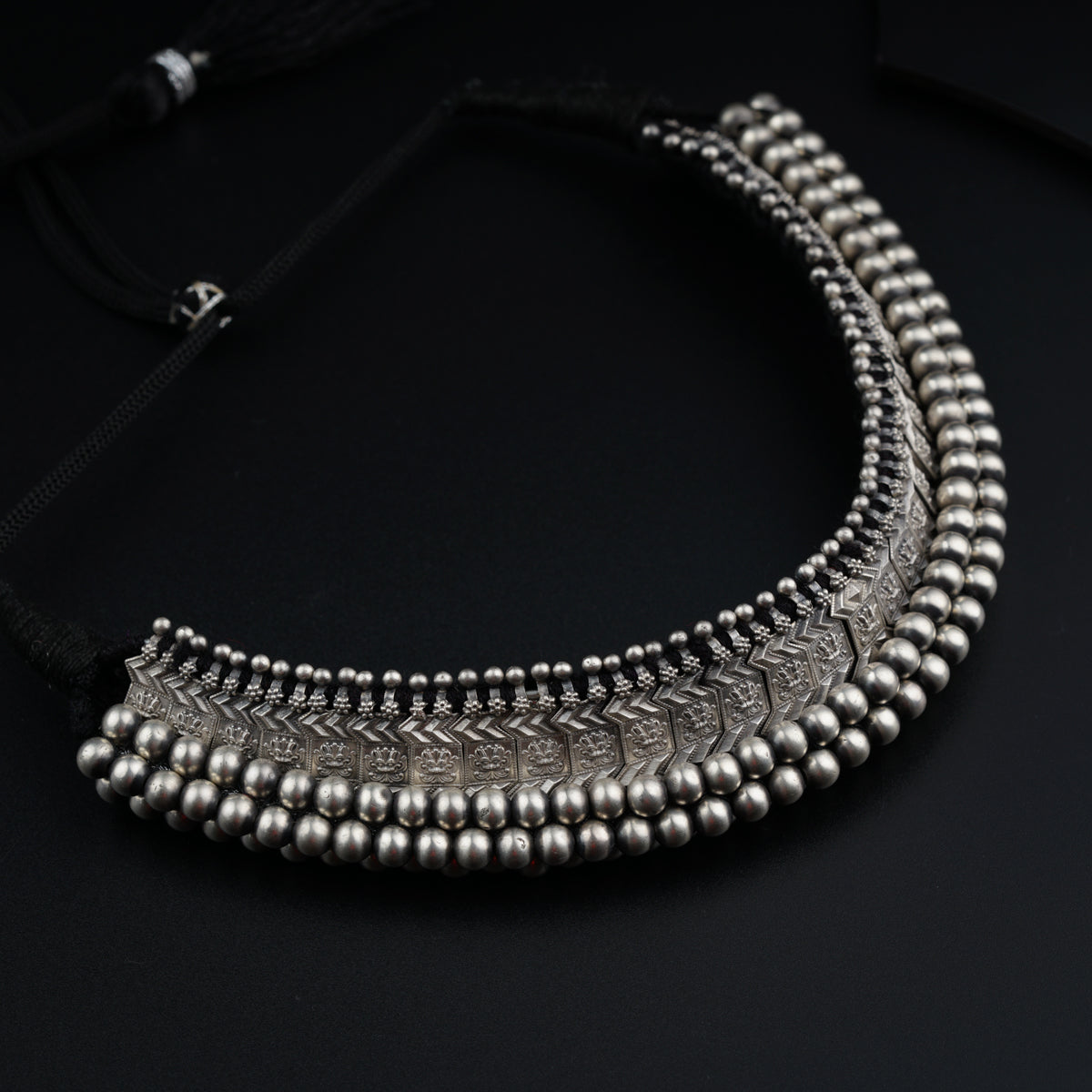 a close up of a necklace on a black surface