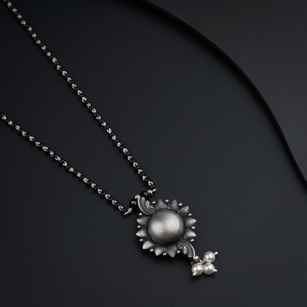a necklace with a flower and a ball on it