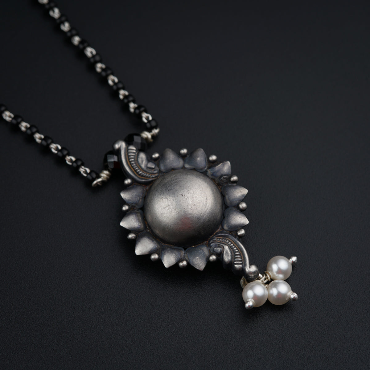 a necklace with a ball and a flower on it