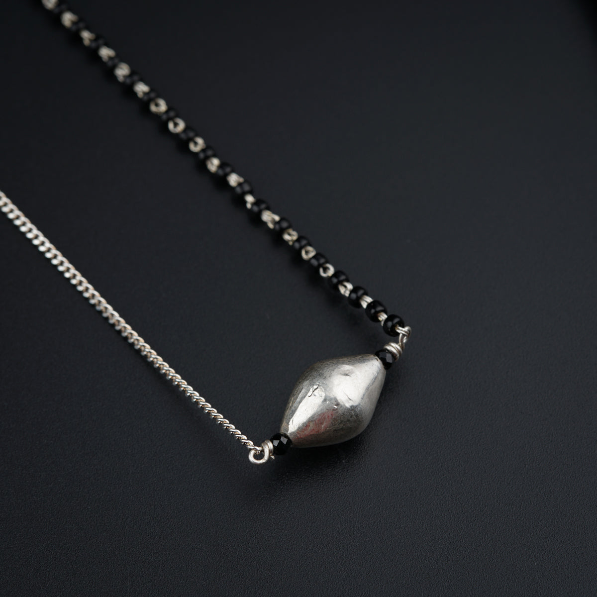 a close up of a necklace on a black surface