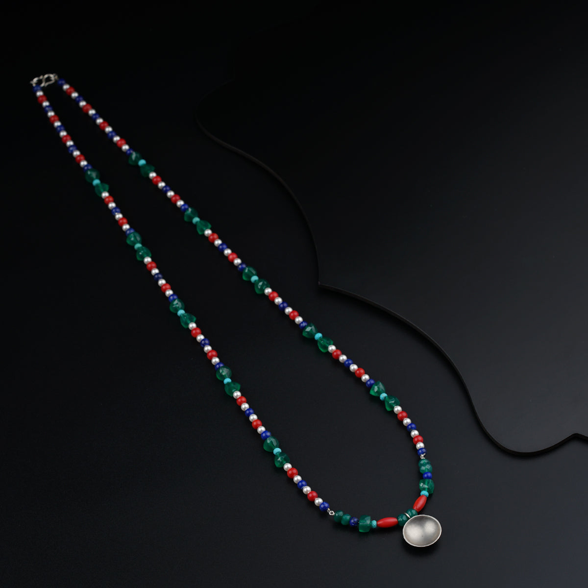 a long beaded necklace on a black surface