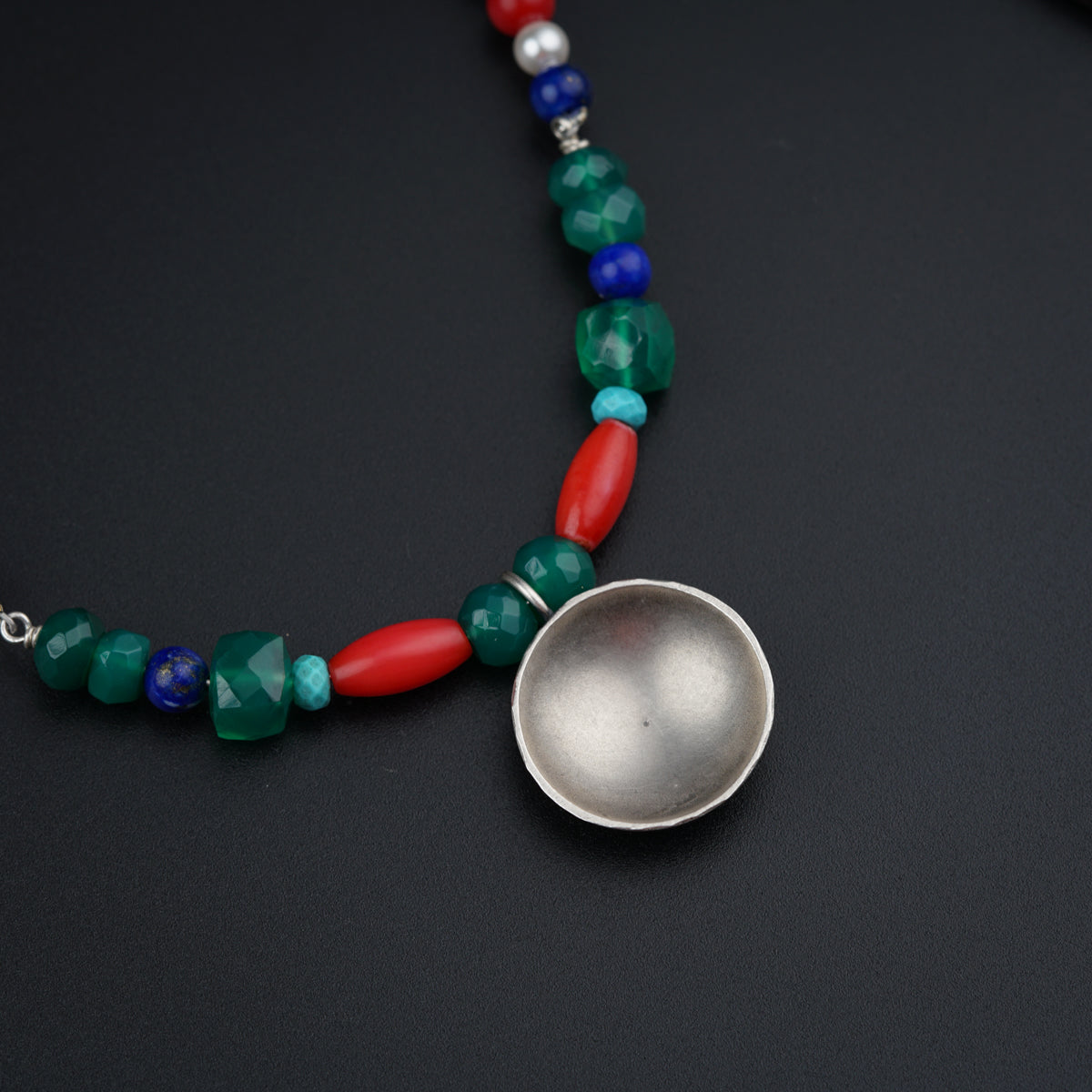 a silver spoon sitting on top of a necklace