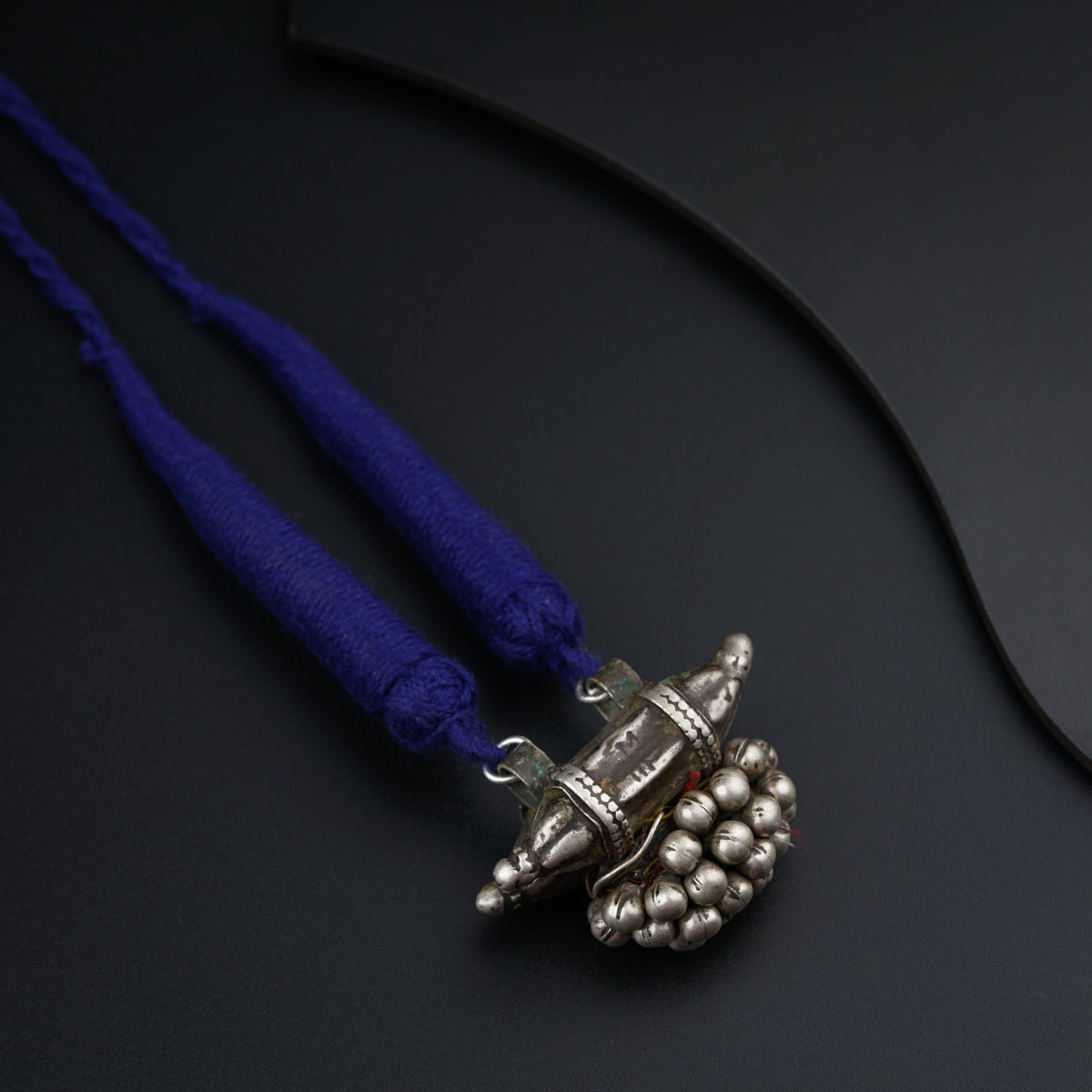 a silver object with a blue cord on a black surface