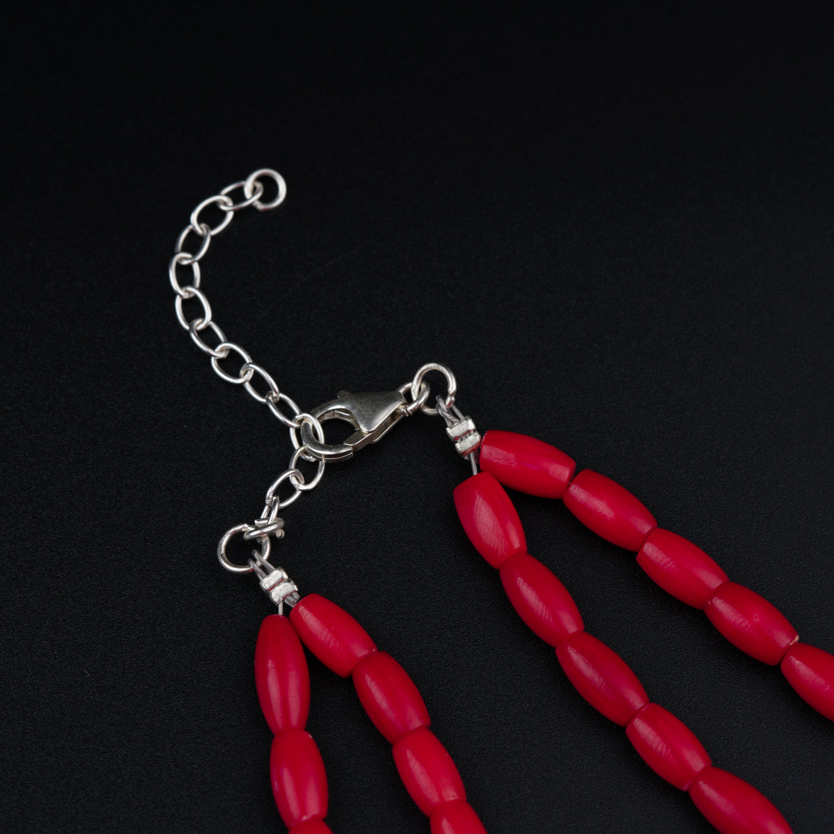 a pair of red beads hanging from a chain