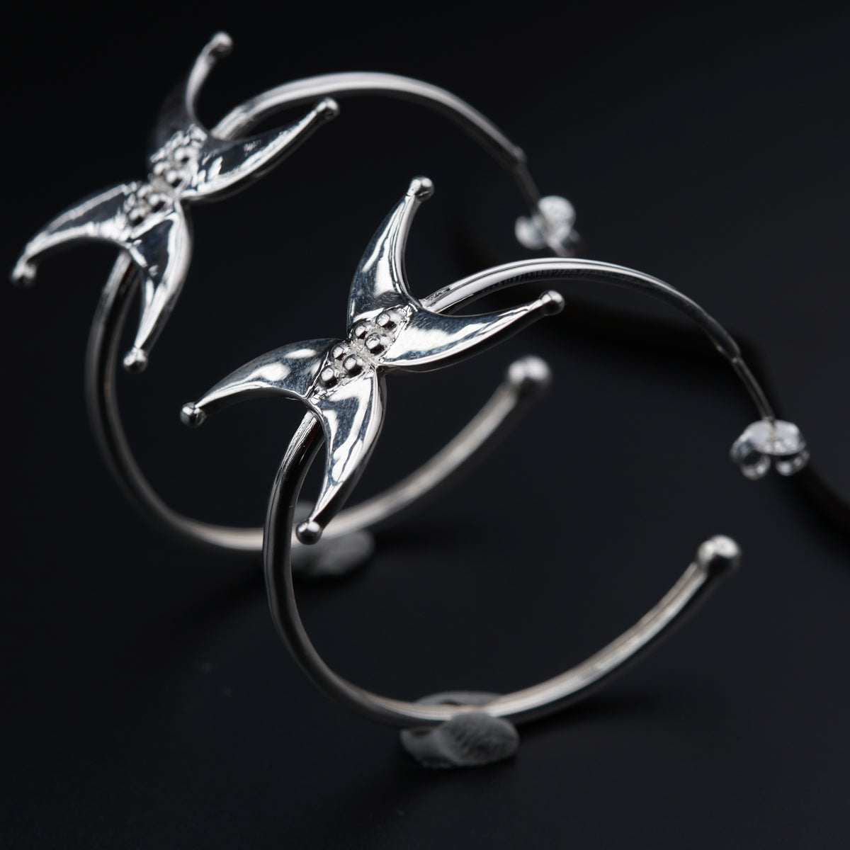 a close up of a pair of silver bracelets