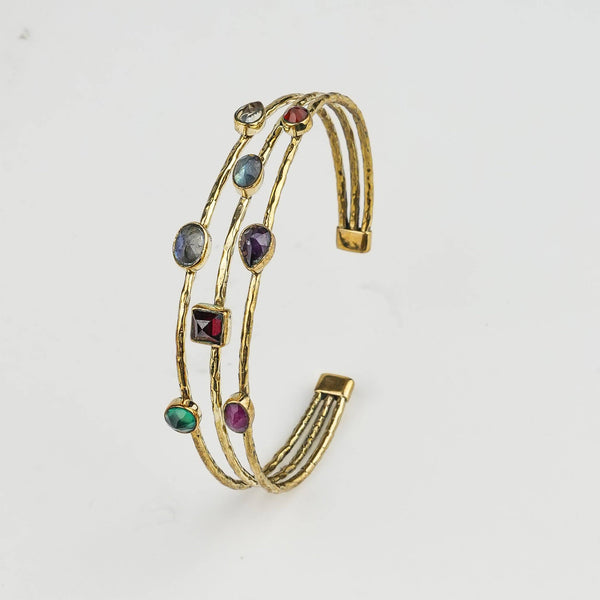 Detailed view of a brass fashion bracelet highlighting intricate motifs, textured surface, and refined brass finish