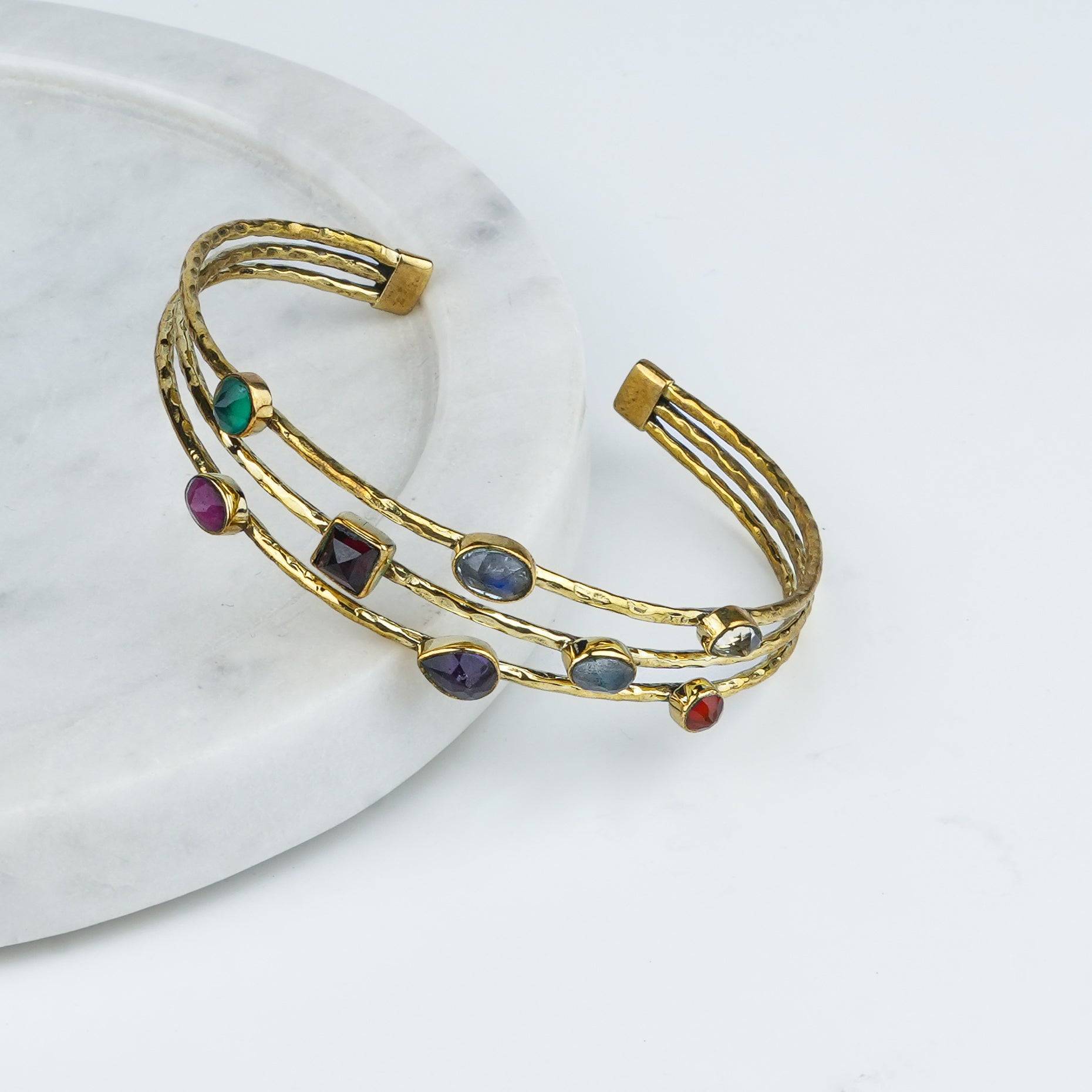 Angled view of a brass fashion bracelet highlighting its unique design, structure, and polished brass finish