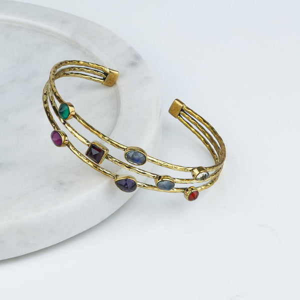 Angled view of a brass fashion bracelet highlighting its unique design, structure, and polished brass finish