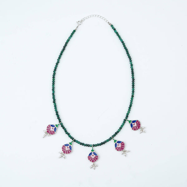 Flat-lay of Rose Enamel Flower Charm Necklace with Green Onyx with floral accessories and complementary silver jewellery