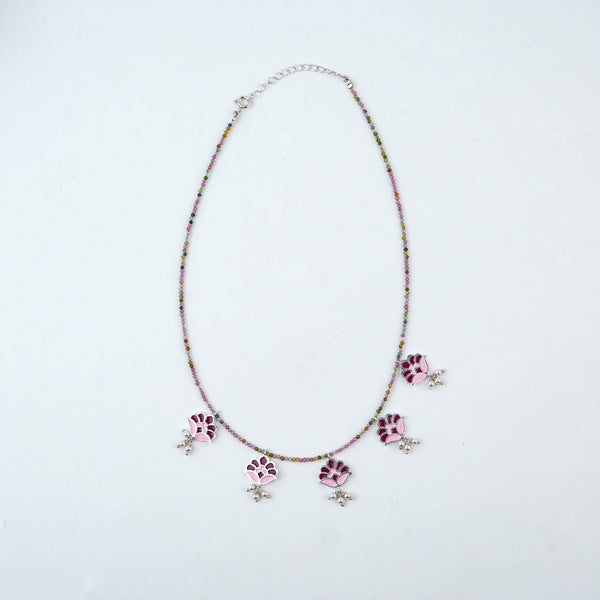 Flat-lay of Enamel Charm Necklace with Tourmaline with colorful charms, natural gemstones, and complementary silver jewellery
