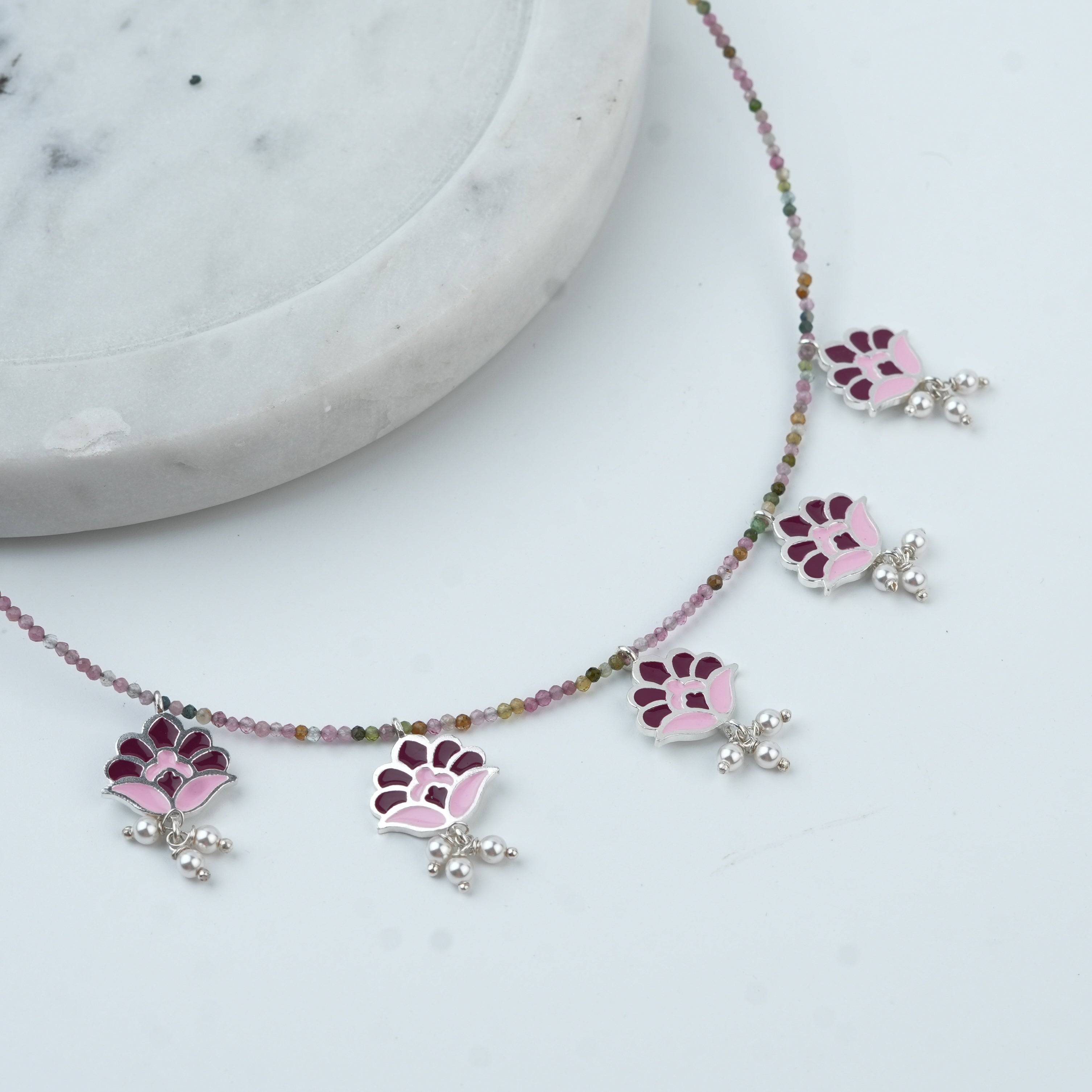 Angled view of Enamel Charm Necklace with Tourmaline in 92.5 sterling silver featuring delicate enamel charms and tourmaline accents