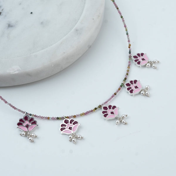 Angled view of Enamel Charm Necklace with Tourmaline in 92.5 sterling silver featuring delicate enamel charms and tourmaline accents
