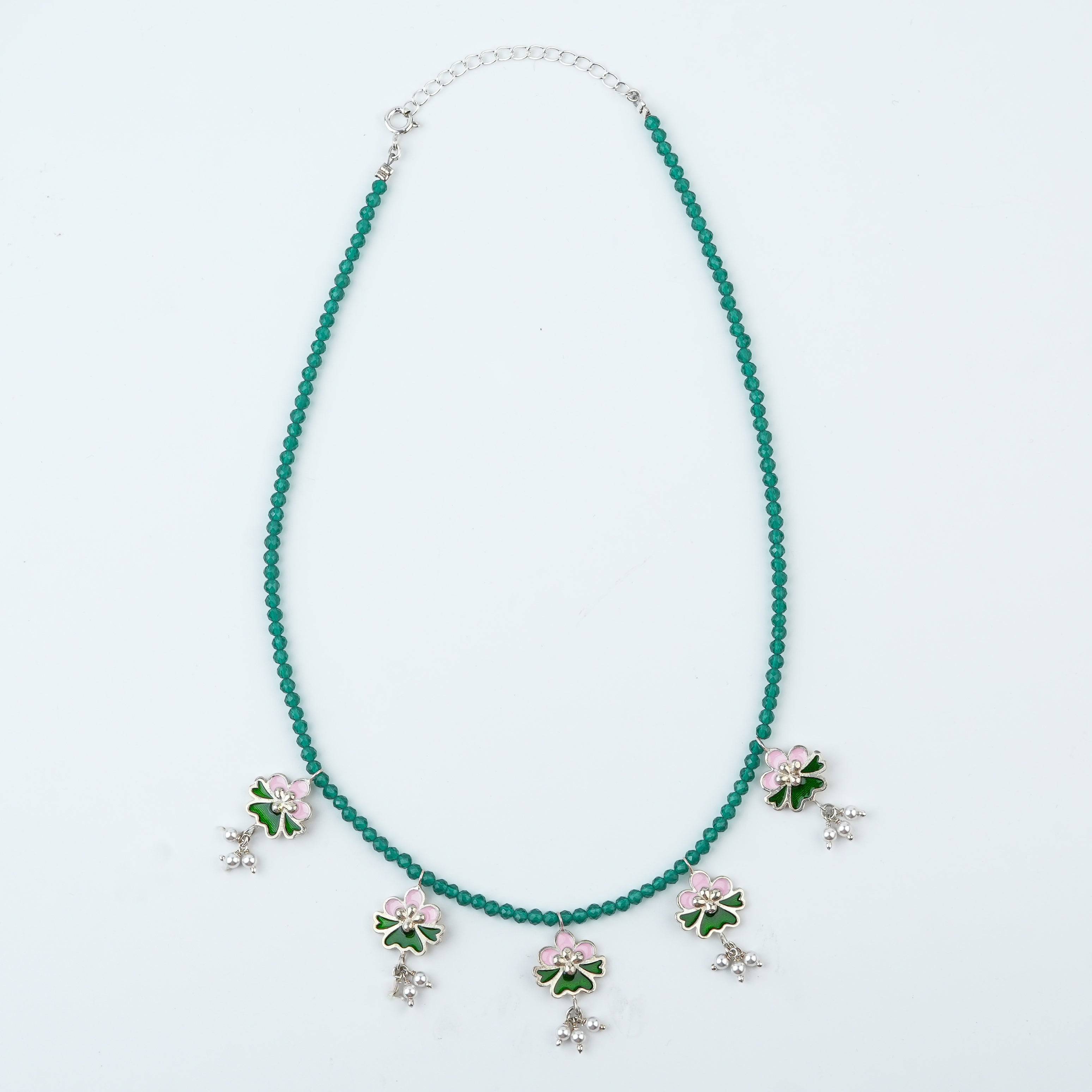 Flat-lay of Pink & Green Enamel Charm Necklace with Green Onyx with colorful accessories and complementary silver jewellery