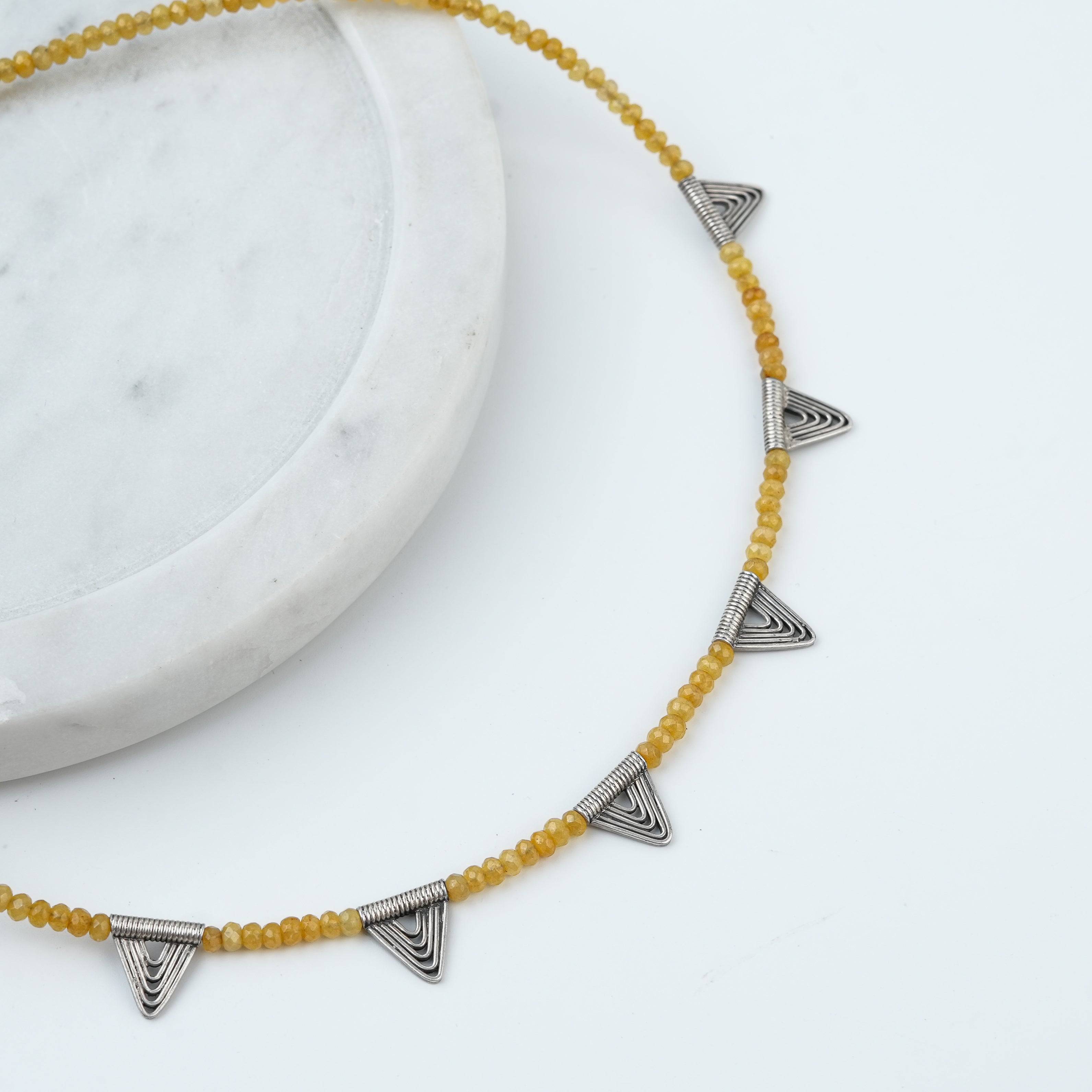 Angled view of Triangle Charm Necklace with Yellow Jade in 92.5 sterling silver featuring an elegant triangle charm