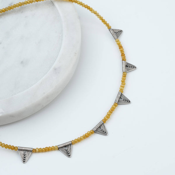 Angled view of Triangle Charm Necklace with Yellow Jade in 92.5 sterling silver featuring an elegant triangle charm